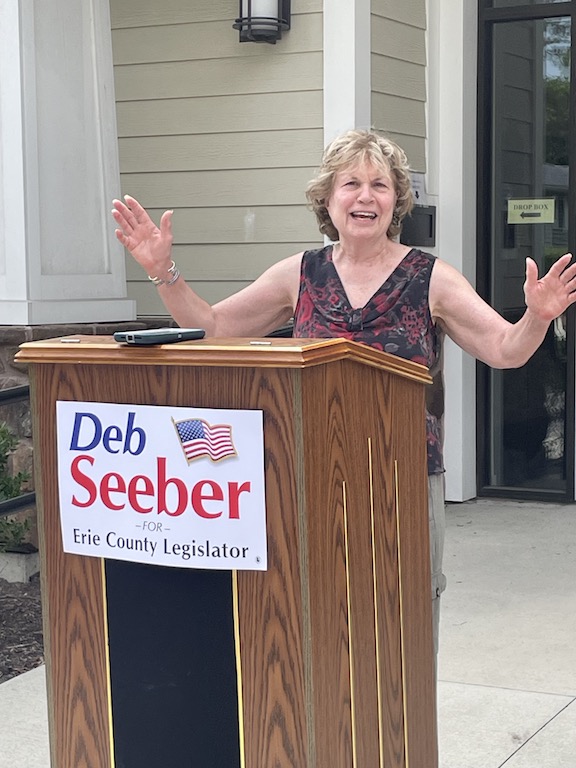 Deb Seeber stands at a podium mid-speech